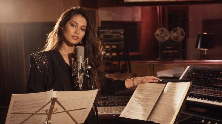 Daniela Romo en un estudio de 1984 junto a dos partituras, escena inspirada en Yo no te pido la luna